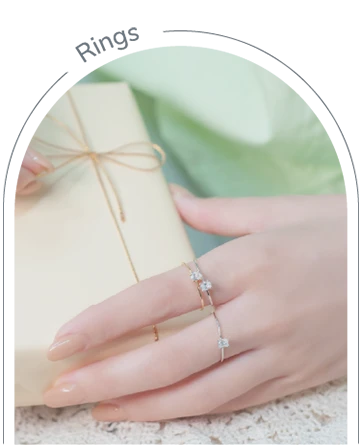 Close-up of a woman's hands holding a refreshing drink, showcasing elegant 14k and 18k rings on her